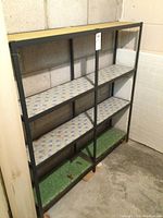 Metal shelf with black frame and four shelves, with patterned and green liners.