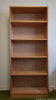 Front view of wooden shelving unit showing all shelves and back panel
