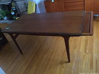 Full view of teak dining table with leaf extended on right side