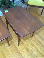Front angled view of vintage teak mid-century modern end table showing wood grain and tapered legs.
