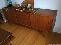 Front view of teak sideboard with drawers and sliding doors