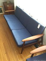 Front-left three-quarter view of the sofa on hardwood floor next to side table