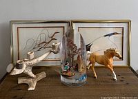 Wide shot of entire lot showing antler candle holder, resin teepee paperweight, horse figurine, and two framed Benjamin Chee Chee prints.