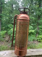 Front view of copper Guardian fire extinguisher with engraved brass plate and operational instructions.