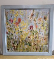Full view of framed floral print on wall, showing colors and frame size.