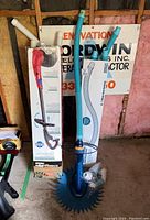 Full view of Zodiac G3 pool vacuum, box of 12 light blue one-meter hoses, and additional hoses and connectors on floor against a sign