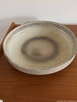 Top view of the pottery dish showing speckled glaze with circular pattern in the center.