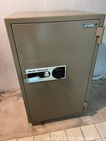 Front view of beige Safeguard SD 106A safe showing combination dial and key lock.
