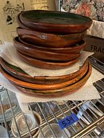 Photo of stacked ceramic plates showing the brown rim edges and green interior glaze with fish design