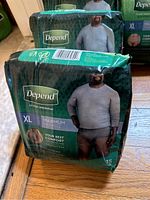 Pack of Depends XL men's disposable underwear, 15 count, in black and green packaging with photo of man wearing grey shirt and briefs.