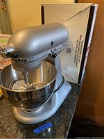 Silver KitchenAid tilt-head mixer with stainless steel bowl on countertop