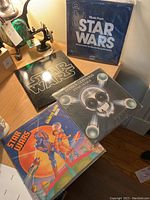 Four Star Wars themed vinyl records displayed on a wooden surface including 'Music From Star Wars' and 'Patrick Gleeson's Star Wars'.