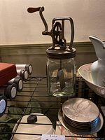 Photo of the vintage hand crank kitchen mixer showing glass jar and metal crank mechanism with wooden handle.