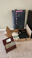 Body Shaping aerobic stepper, jewelry box, box with cables and electronics on carpeted floor