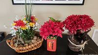 Wide view of three faux flower arrangements, showing details of flowers and containers.