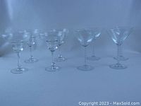 Side view of 8 glasses, showing 4 martini and 4 margarita glasses arranged with room between.