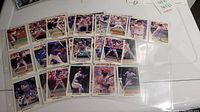 31 baseball cards from the 1990 Leaf Inc. collection arranged on a white surface, showing a mix of players in different baseball actions including batting, pitching, and fielding.
