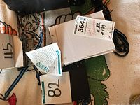 Image of Avigilon ENC-4 port video encoder and packaging including label showing model name, serial number and vendor barcode.