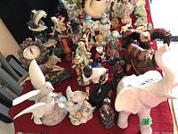 Overview of all figurines including birds, elephant, human figures, clock on table
