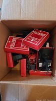 Box containing multiple red Siemens fire alarm pull stations with white text 'FIRE PULL DOWN', showing top view inside the carton.