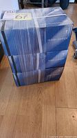 Three stacked blue boxes with Huber & Suhner branding and white shipping tape.