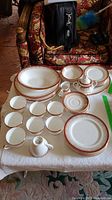 View of the china set arranged on a table showing various plates, bowls, cups, saucers, creamer, and sugar bowl with the Majestic pattern