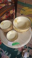 Photo showing stacked small berry bowls and larger vegetable bowl with floral pattern and gold rim
