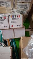 Boxes of STI Stopper Stations SS-2021 showing model and labeling with colored button icons and clear shield protection graphic.