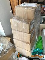 Stack of 11 brown cardboard boxes wrapped in plastic shrink wrap containing Siemens fire horn strobe lights.