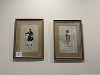 Pair of framed antique military prints displayed on a wall, showing two soldiers from 1722 in dark uniforms, labeled 'Gunner, Royal Artillery'.