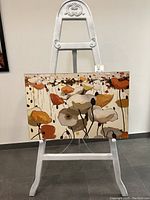Painting displayed on decorative easel, showing full artwork