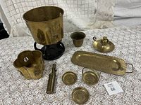 Overview of seven brass items including bucket, tray, small bowls, cup, lidded pot, and telescope item.