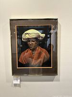 Framed portrait showing the full artwork featuring a woman with a yellow headwrap and orange garment.