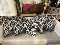 Full view of all seven throw pillows arranged on a couch showing two different patterns.