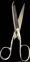 Close-up photo of vintage 7-inch Singer scissors marked 506, showing blades partially open and metal handles.