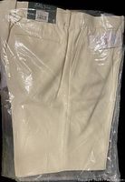 Photo of Bobby Jones men's shorts in sealed packaging showing the stone color and fabric fold.