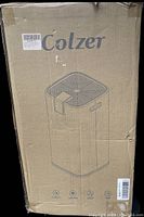 Cardboard box for Colzer dehumidifier showing brand and simple line drawing of unit.