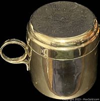 Side view of shiny German silver vintage sippy cup showing round handle and reflective surface with minor scratches.