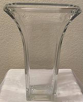 Front view of clear lead crystal vase with wide rectangular flared opening and square base.