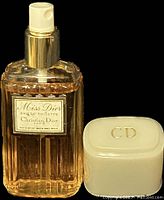Front view of the Miss Dior Eau de Toilette glass bottle with label, gold spray nozzle, and white cap removed showing spray mechanism.