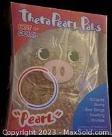 Front view of the TheraPearl Pals Pearl the Pig hot/cold pack in packaging showing pig face and bubble with gel beads inside.