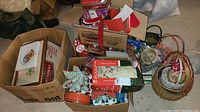 Box filled with wrapping paper, tins, ornaments, and other Christmas decorations.