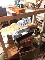 Photo showing vintage Panasonic telephone answering machine, headphones, and parts of the track set box on shelf.