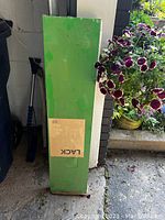 Green rectangular box with Ikea LACK label on it, showing shelf still packed and new.