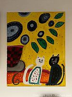 Photo of original chalk paint artwork showing two folk art style cats, decorative leaves, and abstract shapes on a yellow painted canvas.