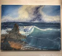 Canvas painting of ocean waves crashing against rocks under a cloudy sky, created with chalk paint.