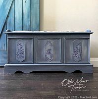 Front view of painted cedar chest with three decorative stenciled panels