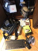 Contents of cabinet showing Midland Wilkie two-way radios, OIZV keyboard, power converter, carrying bags, LED headlight, and adaptor plugs.