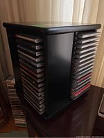 Photo showing black rotating CD rack with many classical music CDs on two visible sides