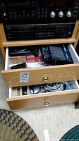 Aiwa HS-P06 cassette player and Sony Discman D-20 CD player stacked, with drawers below containing unused Maxell cassette tapes and cables